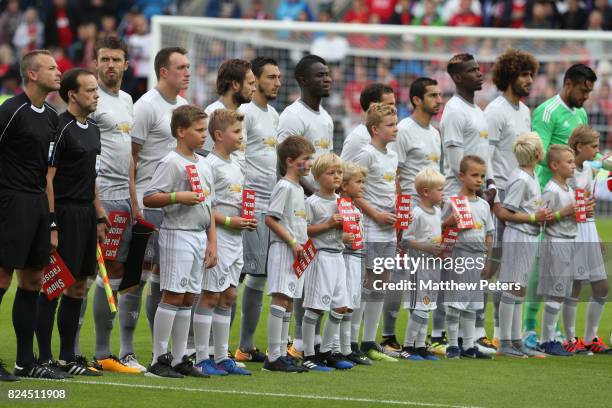 The Manchester United players line up with mascots prior to the pre-season friendly match between Valerenga and Manchester United at Ullevaal Stadion...