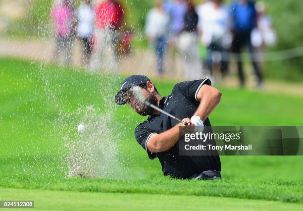 Alexander Levy of France plays out of a bunker onto the 11th green during the Porsche European Open - Day Four at Green Eagle Golf Course on July 30,...