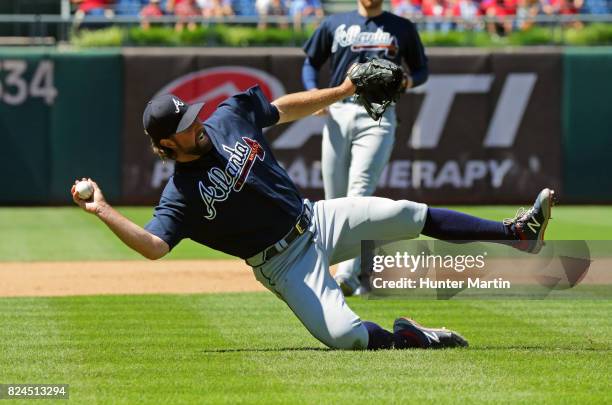 Starting pitcher R.A. Dickey of the Atlanta Braves attempts to make a throw to first base after fielding a ground ball in the fourth inning during a...