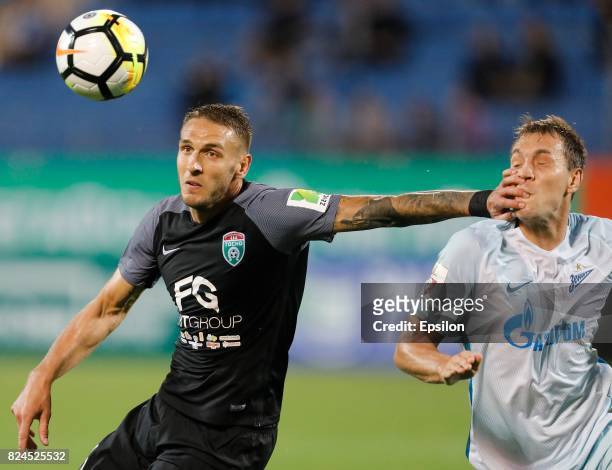 Rade Dugalic of FC Tosno and Artyom Dzyuba of FC Zenit Saint Petersburg vie for the ball during the Russian Football League match between FC Tosno...