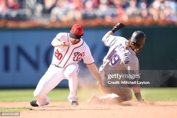 Charlie Blackmon of the Colorado Rockies steals second base on throw to Daniel Murphy of the Washington Nationals in the eight inning during game one...