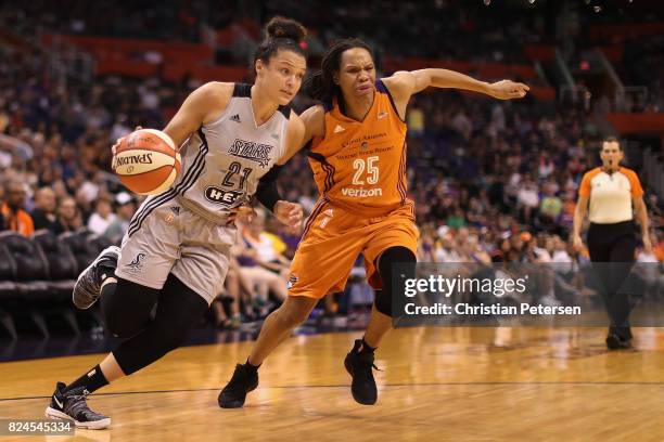 Kayla McBride of the San Antonio Stars drives the ball past Monique Currie of the Phoenix Mercury during the first half of the WNBA game at Talking...