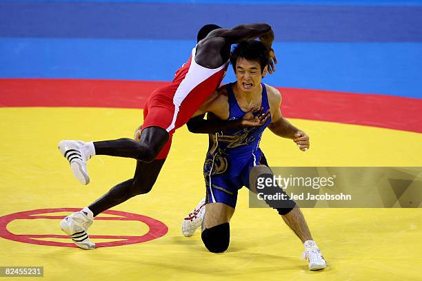 Tomohiro Matsunaga of Japan competes against Adama Diatta of Senegal in the 55 kg freestylewrestling event at the China Agriculture University...