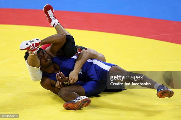 Kenichi Yumoto of Japan competes against Yogeeshwar Dutt of India in the men's 60 kg wrestling event at the China Agriculture University Gymnasium on...
