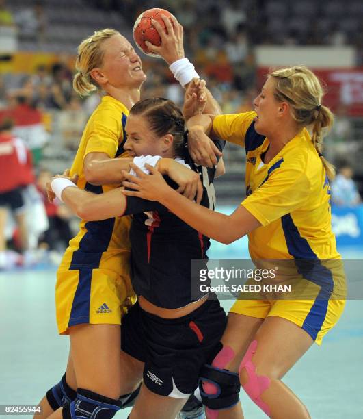 Else Marthe Soerlie Lybekk of Norway vies with Johanna Ahlm and Johanna Wiberg of Sweden during their 2008 Beijing Olympic Games women's handball...