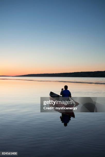 canoeing in to the sunset at buffalo pound provincial park saskatchewan canada - canoe stock pictures, royalty-free photos & images