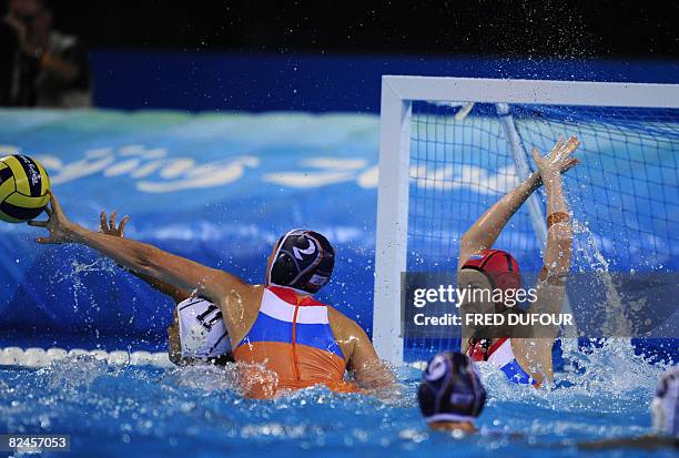 Netherlnad's goalkeeper Ilse van der Meijden and Yasemin Smit vie with Hungarian Agnes Valkai during their women's water polo match of the 2008...