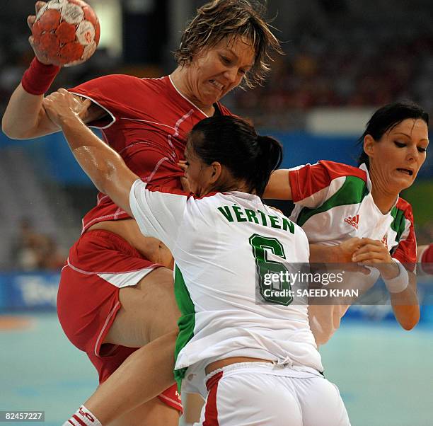 Valeria Bese of Romania is tackled by Orsolya verten and Anita Gorbicz of Hungary during their 2008 Beijing Olympic Games women's handball...