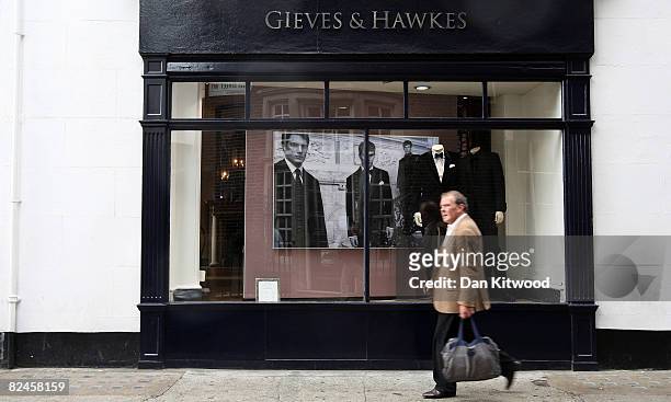 Man walks past Gieves and Hawkes at No 1 Savile Row on August 18, 2008 in London, England. A bespoke two piece suit takes up to eight weeks to make...