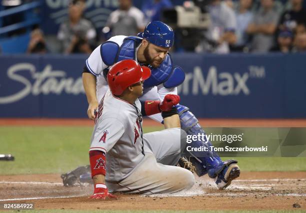 Russell Martin of the Toronto Blue Jays tags out Yunel Escobar of the Los Angeles Angels of Anaheim at home plate in the ninth inning during MLB game...