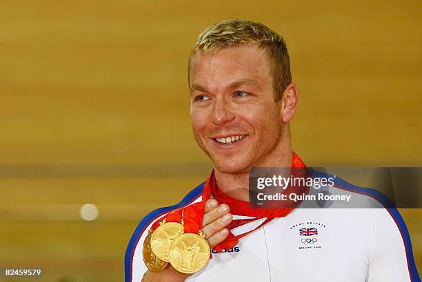 Chris Hoy of Great Britain celebrates with his three gold medals after defeating Jason Kenny of Great Britain in the Men's Sprint Finals in the track...