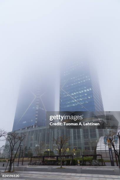 posco e&c tower in incheon on a foggy day - songdo ibd stock pictures, royalty-free photos & images