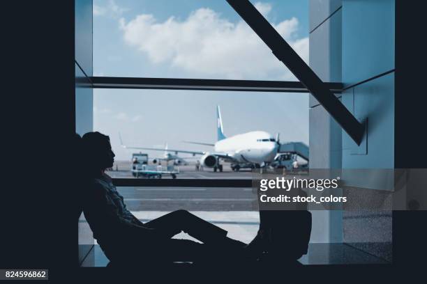 vrouw te wachten voor haar vliegtuig - ongeduldig stockfoto's en -beelden