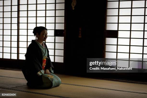 japonesa mujer vestida con un kimono en una habitación de estilo japonés - wabi sabi fotografías e imágenes de stock