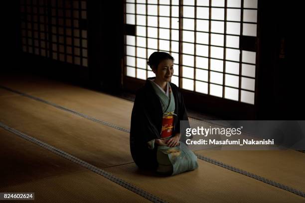 japanische frau trägt einen kimono in einem zimmer im japanischen stil - fersensitz stock-fotos und bilder