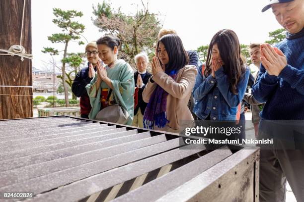 multinational people praying in japanese temples - invocation stock pictures, royalty-free photos & images