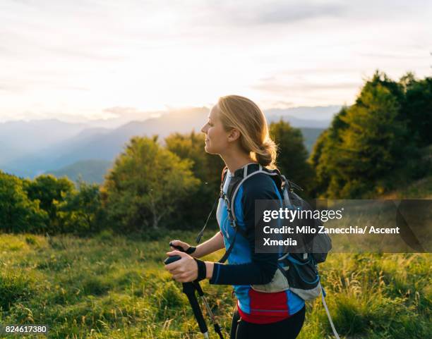 woman hikes along trail at sunrise, mountains - success in a majestic sunrise stock pictures, royalty-free photos & images