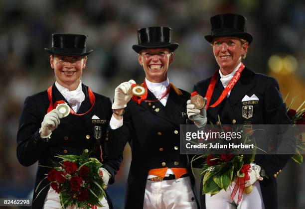 Silver medalist Isabell Werth of Germany, gold medalist Anky van Grunsven of The Netherlands and bronze medalist Heike Kemmer of Germany after the...