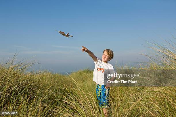 young boy flying a toy glider - gliding stock pictures, royalty-free photos & images