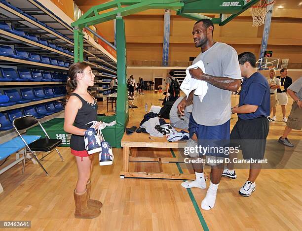 LeBron James of U.S. Men's Senior National Team gives his sneakers to a young girl who found her way into practice during the 2008 Beijing Summer...