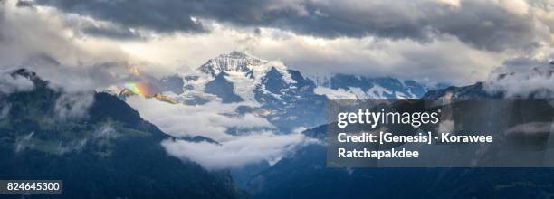 a panorama of jungfrau mountain after raining and has a rainbow beside - eiger mönch jungfrau stock pictures, royalty-free photos & images