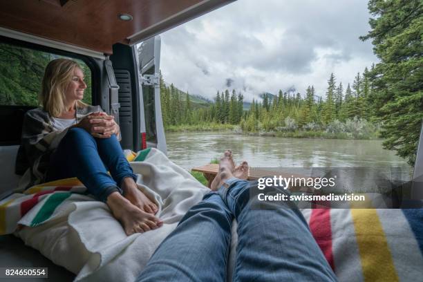 paar met een prachtig uitzicht uit de achterkant van hun busje camping - canmore stockfoto's en -beelden