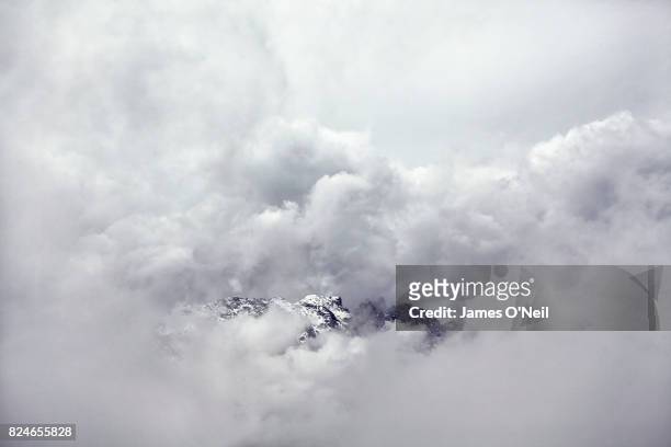 mountains emerging from stormy cloud - appear bildbanksfoton och bilder