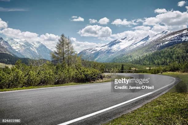 curved empty road on mountain pass, san bernardino, switzerland - wegen stockfoto's en -beelden