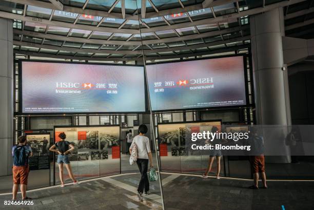 Pedestrians walk through the plaza at the HSBC Holdings Plc headquarters building in Hong Kong, China, on Saturday, July 29, 2017. HSBC is set to...