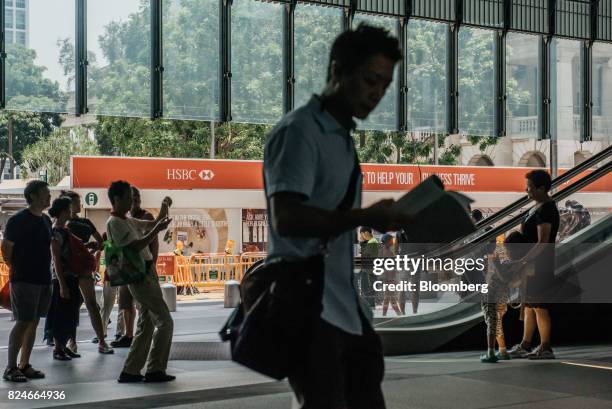 Pedestrians walk through the plaza at the HSBC Holdings Plc headquarters building in Hong Kong, China, on Saturday, July 29, 2017. HSBC is set to...