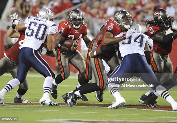 Running back Earnest Graham of the Tampa Bay Buccaneers rushes for a gain against the New England Patriots at Raymond James Stadium on August 17,...