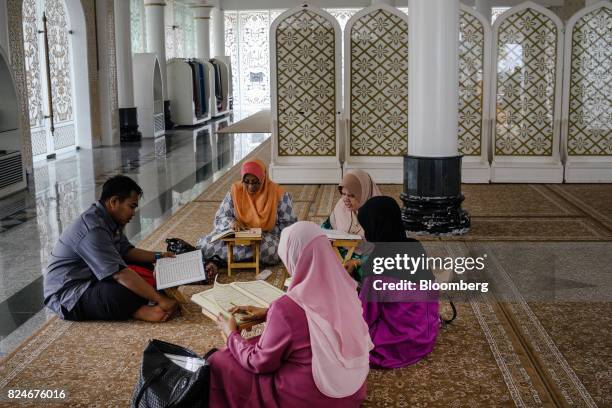 Teacher reads religious texts with visitors at the Crystal Mosque in Kuala Terengganu, Terengganu, Malaysia, on Monday, July 23, 2017. With a federal...