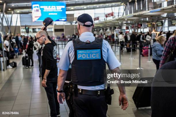 An Australian Federal Police officer on patrol at Sydney Domestic Airport on July 31, 2017 in Sydney, Australia. Counter terrorism police raided four...