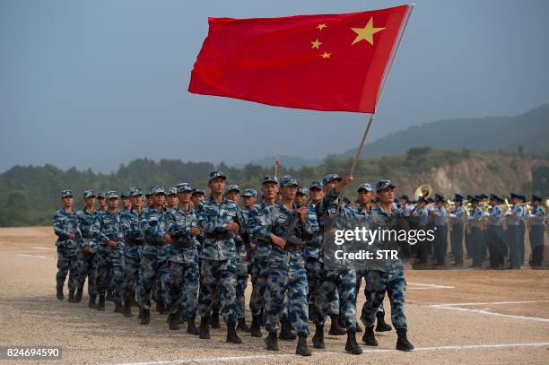 This photo taken on July 30, 2017 shows Chinese People's Liberation Army Air Force personnel marching with their national flag during the opening...