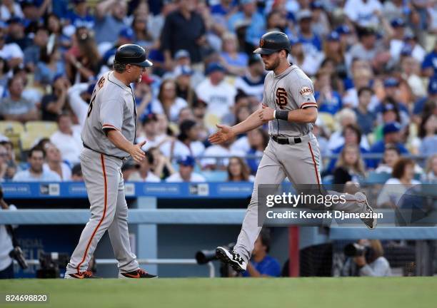 Conor Gillaspie of the San Francisco Giants is congratulated by third base coach Phil Nevin after hitting a one run home run against Los Angeles...