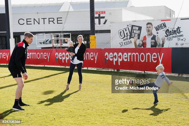 Nick Riewoldt and wife catherine holding son William watch their other son James kick a football after he announces his retirement during a St Kilda...