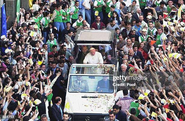 Pope John Paul II is greeted by thousands of well-wishers as he arrives at the Roman Catholic Patriarch, May 7, 2001 in Damascus, Syria.