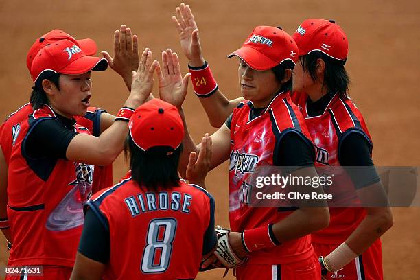 Rei Nishiyama , Megu Hirose and Yukiko Ueno of Japan greet each other after they got out of an inning without giving up a run against the United...