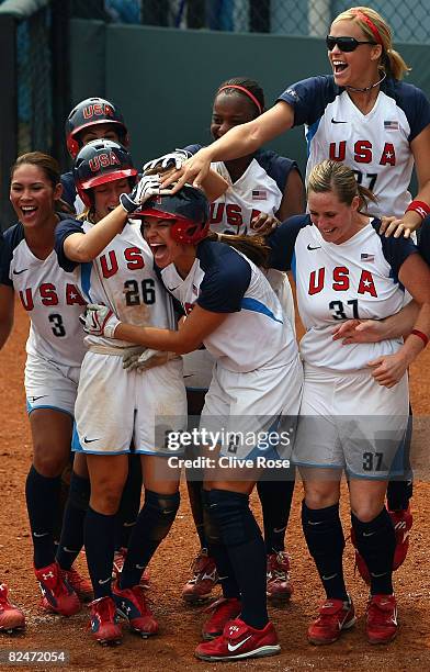Jessica Mendoza and Caitlin Lowe of the United States are greeted by Lovieanne Jung, Lauren Lappin and Jennie Finch at home plate after they scored...