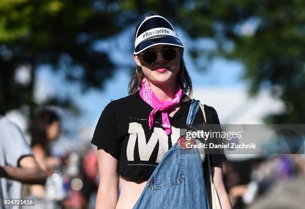 Festival goer is seen wearing a jeans jumpsuit, Flavorlife visor and pink bandana during the 2017 Panorama Music Festival Day 3 at Randall's Island...