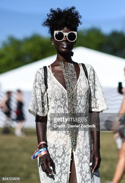 Festival goer is seen wearing a white sheer floral dress with white sunglasses during the 2017 Panorama Music Festival Day 3 at Randall's Island on...