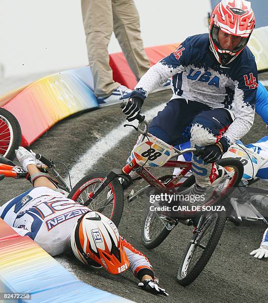 Raymon Van der Biezen of Netherlands and United States' Kyle Bennett crash during their men's cycling BMX quaterfinal at the Laoshan BMX Venue during...