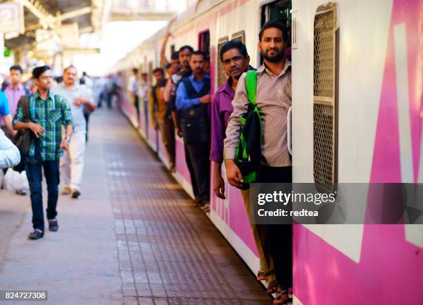 people travelling on local indian train into mumbai - mumbai train stock pictures, royalty-free photos & images