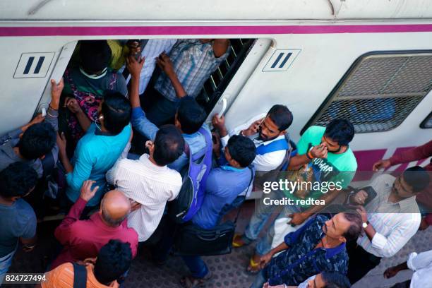 people travelling on local indian train into mumbai - mumbai local stock pictures, royalty-free photos & images