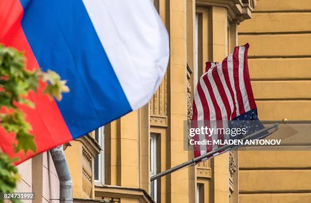 Russian flag flies next to the US embassy building in Moscow on July 31, 2017. - President Vladimir Putin on July 30, 2017 said the United States...