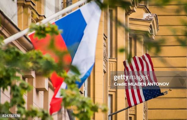 Russian flag flies next to the US embassy building in Moscow on July 31, 2017. - President Vladimir Putin on July 30, 2017 said the United States...