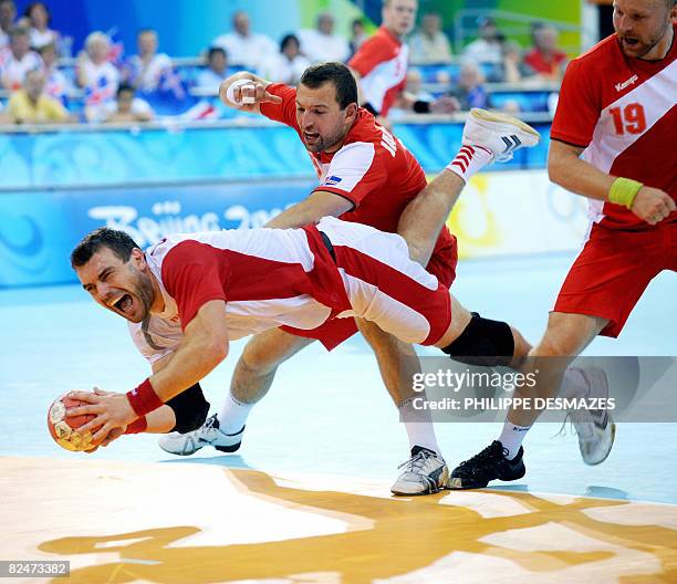 Bartosz Jurecki of Poland vies with Sverre Jakobsson and Ingimundur Ingimundarson of Iceland during their 2008 Beijing Olympic Games men's handball...