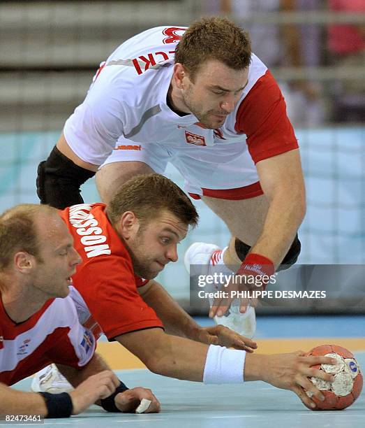 Sverre Jakobsson and Olafur Stefansson of Iceland vies with Karol Bielecki of poland in their men's quarterfinals handball match at the Beijing 2008...