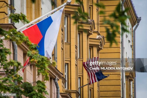 Russian flag flies next to the US embassy building in Moscow on July 31, 2017. - President Vladimir Putin on July 30, 2017 said the United States...