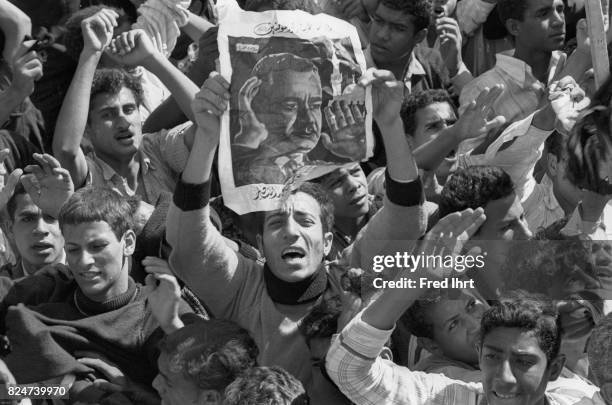 Crowds of mourners, most of them young men. Some carrying banners with the portrait of Gamal Abd al-Nasser in the streets of cairo during the funeral...